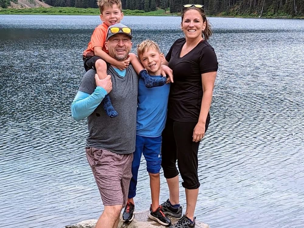 Kevin with Dr. Nicole Rodriguez and their sons at a mountain lake.